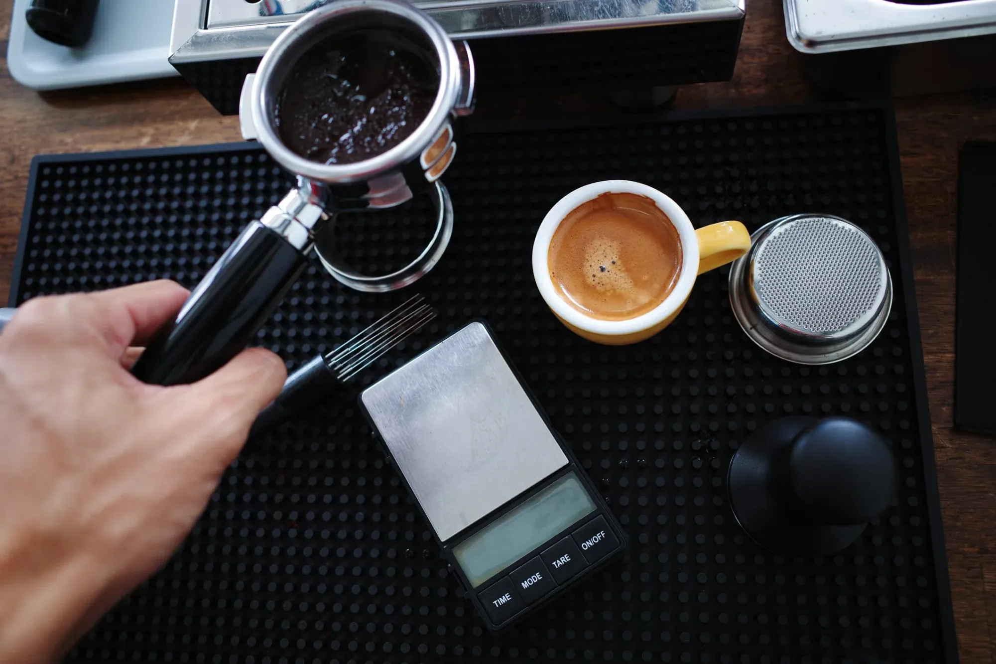 hand holding a used portafilter with wet coffee grounds inside