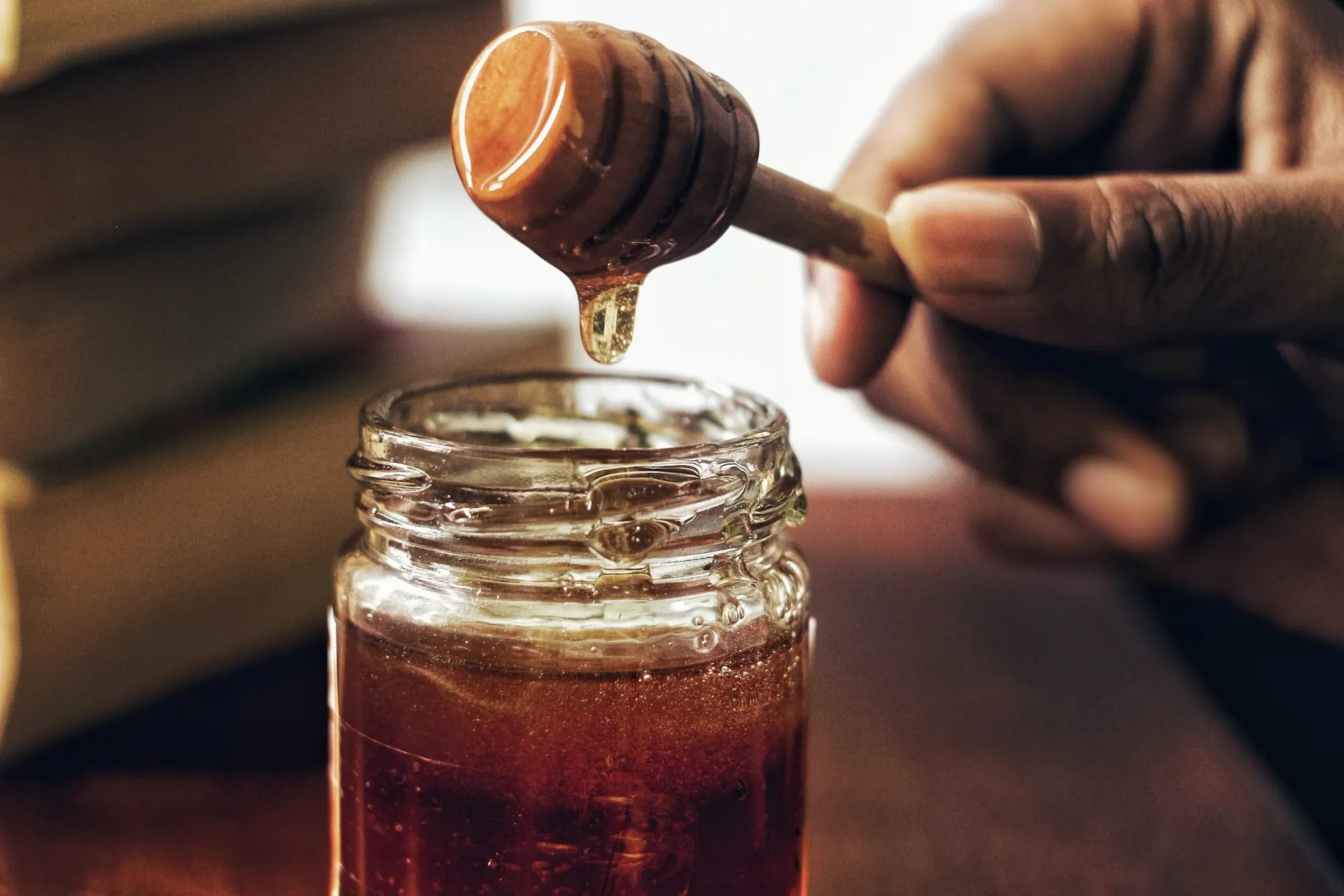 honey dripping over a jar
